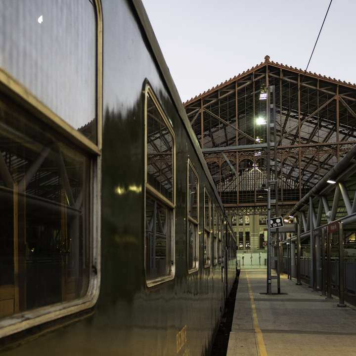  The historic Felipe II train stopped at Madrid's Príncipe Pío station. The green vintage carriage reflects the station's ironwork and soft twilight ambiance, showcasing timeless railway heritage. 